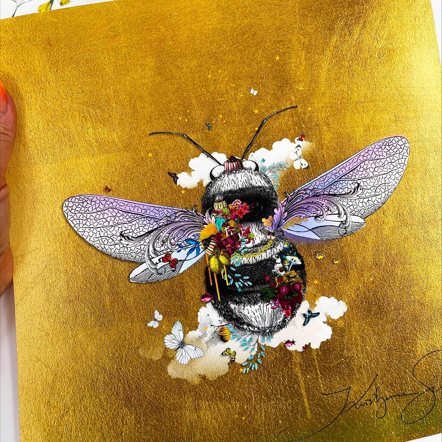 warm golden honey bee limited edition print black and grey honey bee with purple wings covered in bright yellow purple red flowers surrounded by butterflies and birds and clouds set on a gold leaf background by artist Kristjana Williams