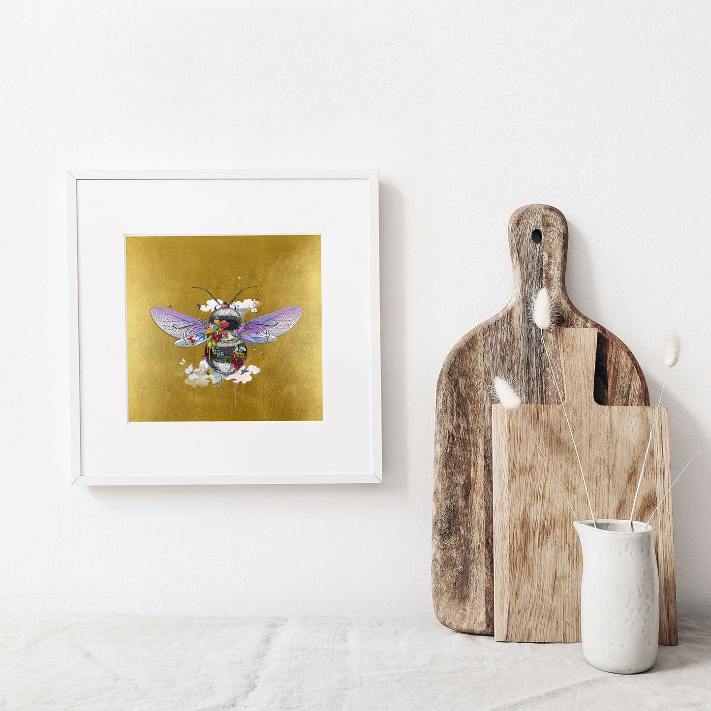 warm golden honey bee limited edition print black and grey honey bee with purple wings covered in bright yellow purple red flowers surrounded by butterflies and birds and clouds set on a gold leaf background by artist Kristjana Williams